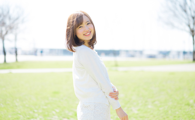 春の草原を散歩する女性